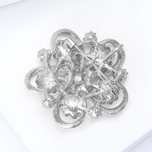 Detailed back view of silver hollow floral brooch showing secure safety pin closure