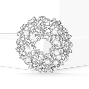 Elegant silver sun flower brooch with white pearls and sparkling crystals on white background