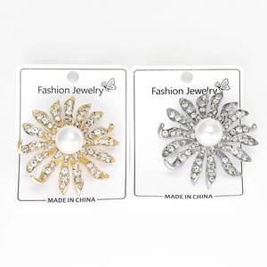 Vue détaillée de broches fleur de soleil en or et argent avec perles et strass brillants