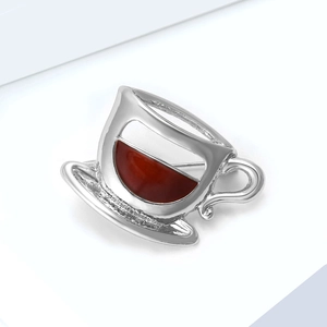 Vue détaillée d'une broche en forme de tasse à café argentée avec émail marron rouge