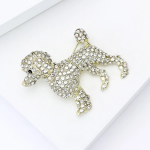 Vue détaillée d'une broche caniche dorée avec des strass blancs étincelants et un œil noir