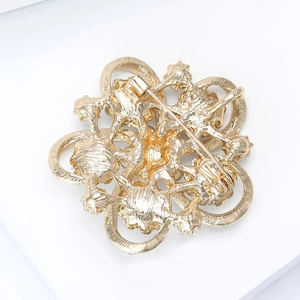 Back view of gold hollow floral rhinestone brooch with a secure long pin closure