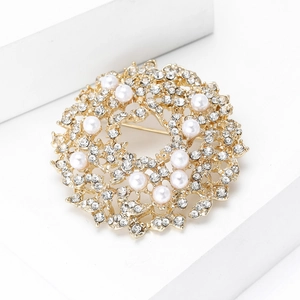 Elegant gold sun flower wreath brooch with crystal rhinestones and white pearls on white stand
