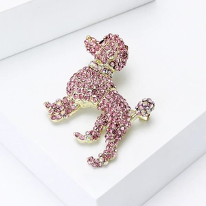 Vue détaillée d'une broche caniche en strass roses et métal doré sur un support géométrique blanc