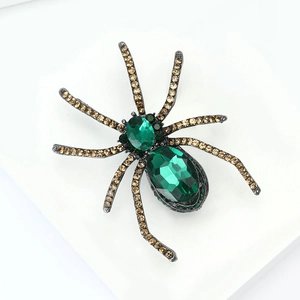Macro shot of vintage spider brooch with green crystals and champagne diamonds details