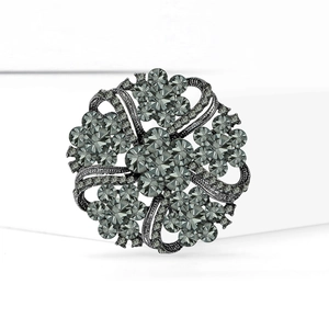 Vintage dark metal round wreath brooch with grey crystals and floral scrollwork pattern