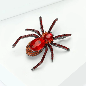 Macro detail of retro spider brooch with red faceted crystals and sparkling rhinestones