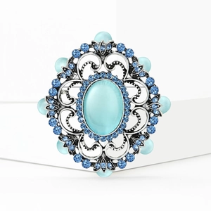 Broche baroque vintage avec pierre œil de chat bleue et détails de strass en argent vieilli
