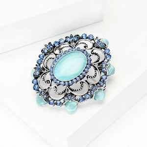 Vue détaillée de la broche baroque vintage avec pierre œil de chat bleue et métal filigrane