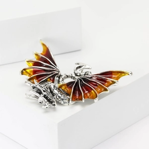 Macro detail of western dragon brooch showing intricate scales and fiery enamel wings