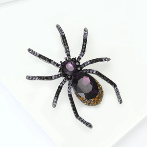Macro shot of spider brooch with purple teardrop gemstones and gothic rhinestone details