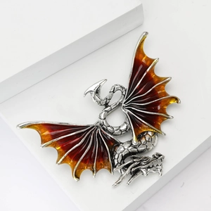 Detail of western dragon brooch with amber gradient enamel wings and silver scales