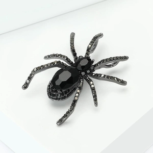 Detail view of vintage spider brooch featuring black rhinestones and faceted gemstones