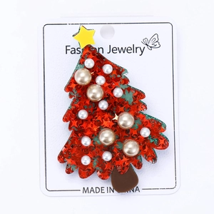 Detail of Christmas tree brooch with red star sequins and faux pearls on display card