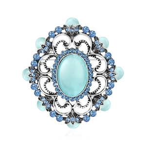 Broche baroque vintage avec œil de chat bleu et strass sur une base florale en argent