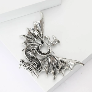 Macro detail of gothic flying dragon brooch showing antique silver alloy wings and pin back