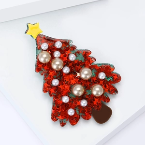 Christmas tree brooch with red star sequins and pearls on a minimalist white stand