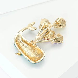 Back view of a gold-plated whale brooch featuring a secure rotating pin clasp