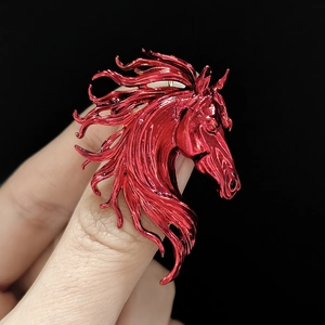 Macro view of vibrant red horse head brooch with sleek metallic mane and polished finish