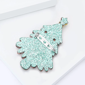 Detailed back view of a green glitter Christmas tree brooch with silver metal pin fastening