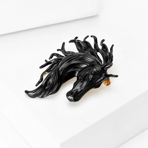 Detail of horse head brooch featuring black enamel finish and gold metal hardware