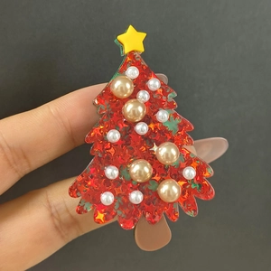 Detail of red acrylic Christmas tree hair claw clip with star sequins and pearls
