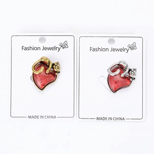 Macro detail of red heart-shaped cat brooches in gold and silver finish with glitter