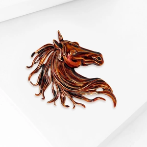 Detailed macro view of the vintage reddish-brown horse head brooch with glossy finish