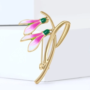 Squisita spilla a fiore di bucaneve in lega dorata con smalto rosa e verde su sfondo bianco