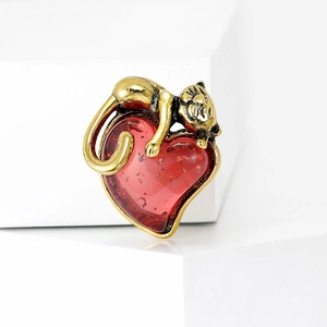 Retro gold cat brooch with deep red heart pendant on minimalist white background
