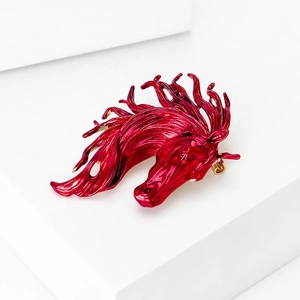 Detailed macro view of a vibrant red horse head brooch with smooth enamel finish