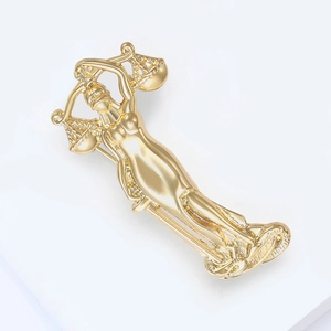 Detailed side view of golden Goddess of Justice brooch with scales and hollowed carving