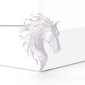 Macro detail of silver horse head brooch with iridescent finish on minimalist background