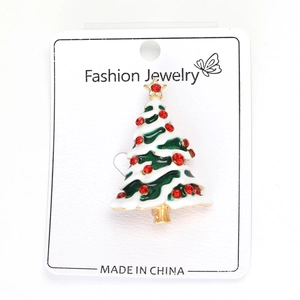 Close-up of Christmas tree brooch with green enamel waves and red rhinestones