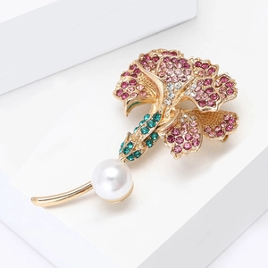 Close-up of elegant enamel carnation flower brooch with pink rhinestones and a white pearl