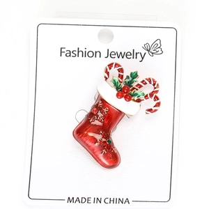 Detailed close-up of a festive red enamel Christmas stocking brooch with rhinestones