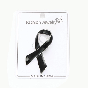 Détail d'une broche ruban en émail noir avec bordure argentée sur carte cadeau