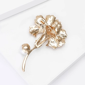 Detail of the back side craft and safety pin mechanism on the golden carnation brooch
