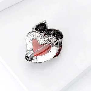 Close-up of heart cat brooch back showing silver metal texture and safety pin mechanism
