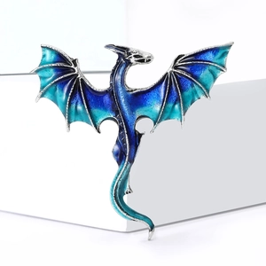 Silver dragon brooch with blue gradient enamel wings on white geometric background