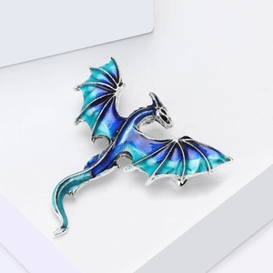 Detail of western dragon brooch with blue gradient enamel wings on white background