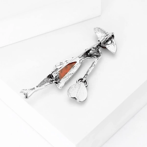 Vintage silver lady with hat brooch featuring an amber-colored resin heart center