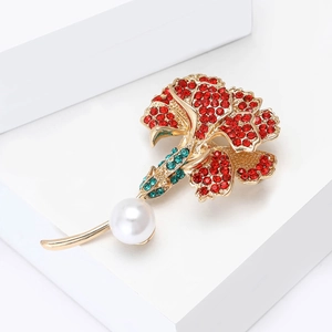 Detailed close-up of a flower brooch with red rhinestones and white imitation pearl