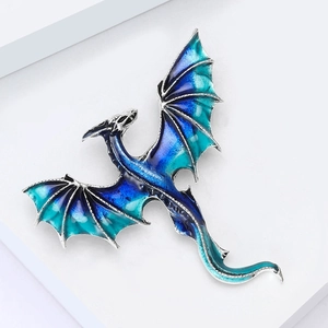 Close-up of Western dragon brooch with blue enamel wings and silver metallic details