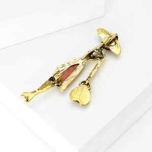 Vintage gold silhouette brooch featuring an elegant lady with a red amber gemstone inlay