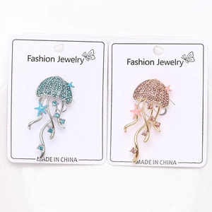 Detail of jellyfish brooches with colorful rhinestones and starfish charms on metal