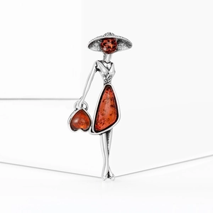 Detailed view of silver brooch featuring a vintage lady design with amber resin stones