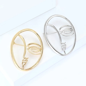 Minimalist abstract face outline brooches in gold and silver finish on white display
