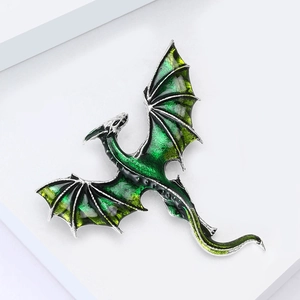 Macro view of flying dragon brooch with green gradient enamel and silver metal scales