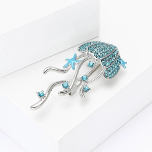 Detail showing blue rhinestones and starfish charms on a jellyfish brooch pin